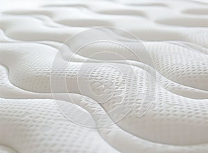 A close-up shot of the texture and pattern on a mattress, highlighting its softness and comfort for sleeping. The