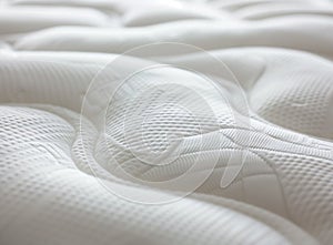 A close-up shot of the texture and pattern on a mattress, highlighting its softness and comfort for sleeping. The