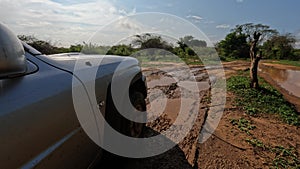 A close-up shot of a tire on a 4x4 vehicle driving through the muddy road from Tsingy de Bemaraha to Morondava in Madagascar