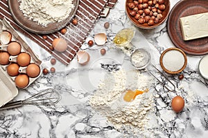 Close-up shot. Top view of a baking ingredients and kitchenware on the marble table background.