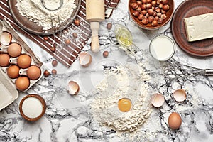 Close-up shot. Top view of a baking ingredients and kitchenware on the marble table background.