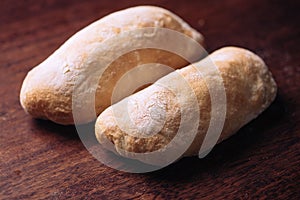 Close-up shot of two loaves of freshly-baked bread on a rustic wooden table