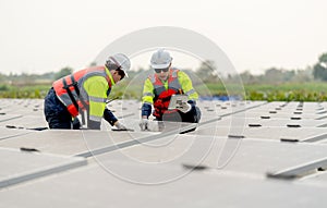 Close up shot of two technician workers sit and work on process of maintenance solar cell panel network system in concept of green