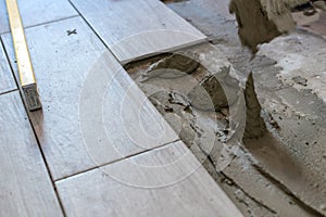 Close up shot of unfinished floor tiles installation in kitchen