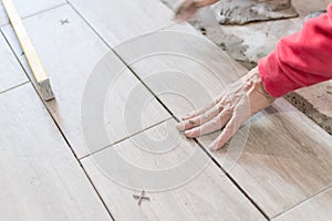 Close up shot of unfinished floor tiles installation in kitchen