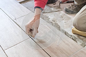 Close up shot of unfinished floor tiles installation in kitchen