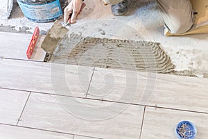 Close up shot of unfinished floor tiles installation in kitchen