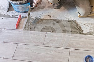 Close up shot of unfinished floor tiles installation in kitchen