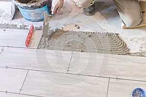 Close up shot of unfinished floor tiles installation in kitchen