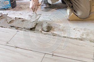 Close up shot of unfinished floor tiles installation in kitchen