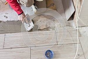 Close up shot of unfinished floor tiles installation in kitchen