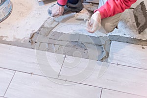 Close up shot of unfinished floor tiles installation in kitchen