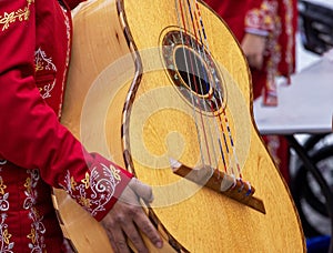 Close up shot of unrecognizable mariachi woman, holds a mariachi GuitarrÃÂ³n Mexicano (big photo