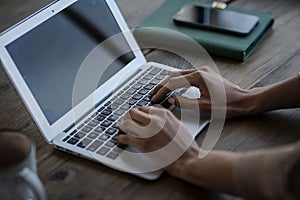 Close-up shot of an unrecognizable woman using laptop