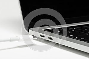 Close up shot of usb c cable plugging to a laptop computer