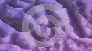 Close up shot of violet pink cream background. Face or body cream fluid texture with peaks rotating. Smooth moisturizer