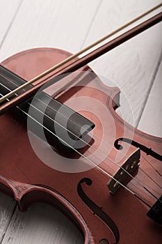 Close-up shot violin orchestra instrumental with vintage tone processed over white wooden background select focus shallow depth of