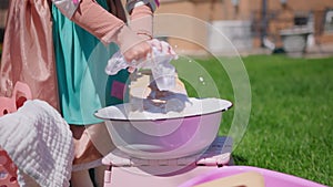 Close up shot of Washing clothes on old vintage washboard outdoors. Young Woman washing on old retro washboard