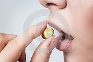 Close-up shot of woman brings the pill to her mouth.