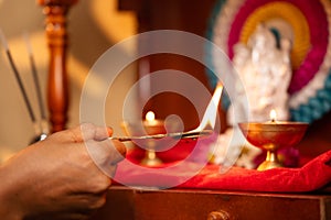 Close up shot of woman hands worshipping offering aarthi to god during morning - concept of rituals, traditional custom