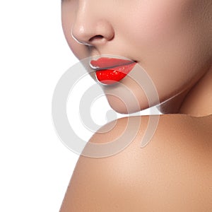 Close-up shot of woman lips with glossy red lipstick