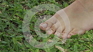 Close up shot of a woman standing barefoot and feeling the grass