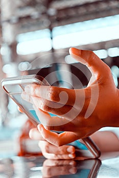 Close up shot of a woman using a mobile phone in a cafe