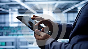 Close up shot of worker in server room using tablet
