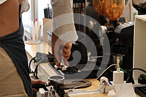 Close-up shot of young beautiful baretta making coffee with modern coffee machine.