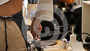 Close-up shot of young beautiful baretta making coffee with modern coffee machine.