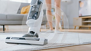 Close Up Shot of a Young Beautiful Woman in Jeans Shirt and Shorts Vacuum Cleaning a Carpet in a B