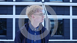 Close up shot of a young man in a glasses looking at the side on the grey background