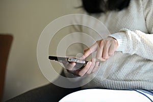 Close-up shot, A young woman using her smartphone, touching on her phone screen