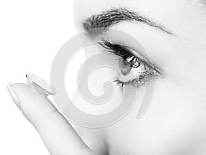 Close-up shot of young woman wearing contact lens.