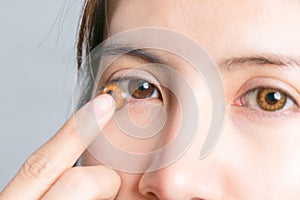 Close-up shot of young woman wearing contact lens