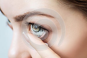 Close-up shot of young woman wearing contact lens.