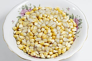 Close-up shots of multiple corn seeds in the small white cup