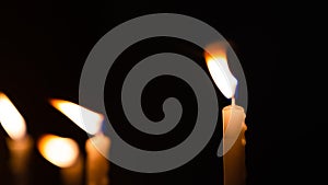 Close-up shots of yellow candles and lights on a black background with bokeh lights