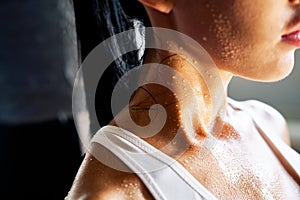 Close up shoulders and neck of sporty girl in drop of sweat on skin after workout photo