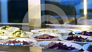 close-up, showcase with salads in canteen, mess hall, cafeteria, Food Buffet resturant. buffet worker lays out food on