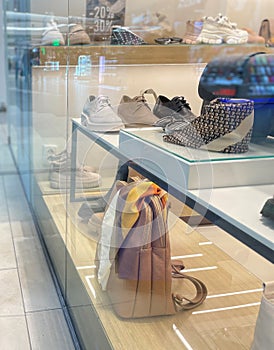 Close up of showcase with shoes and bags. Fashion boutique in shopping mall. Show window with stylish accessories