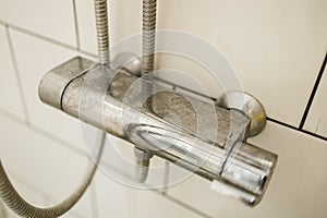 Close-up of shower mixer faucet with limescale, white chalky deposit and stains. Formed on the plumbing system by a