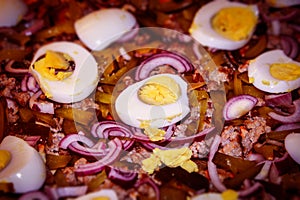 Close-up shows the ingredients for homemade pizza: pickles, minced meat, onion, boiled egg