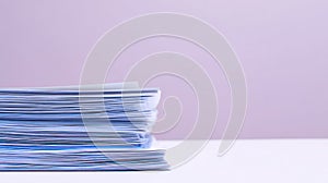 Stack of papers on white surface with purple background