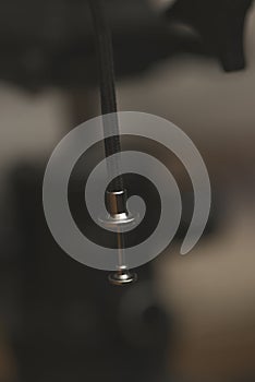 Close up of a shutter release cable tip with braided cord in soft warm studio lighting