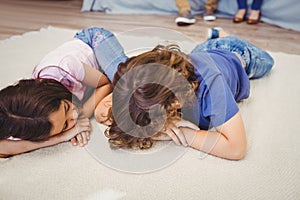 Close-up of siblings relaxing on carpet