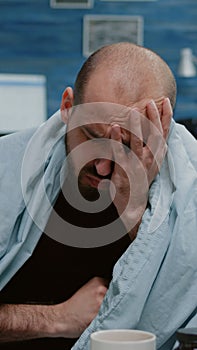 Close up of sick man blowing runny nose with tissues