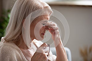 Close up of sick senior female suffer from blurry vision