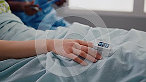 Close up of sick woman resting in bed in hospital ward