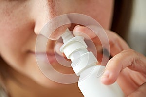 Close up of sick woman using nasal spray